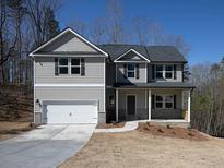 Charming two-story home with a covered porch, attached garage, and well-manicured lawn on a sunny day at 250 Shawnee Trl, Dallas, GA 30157