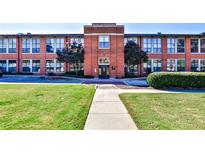 Brick apartment building with a manicured lawn and walkway leading to the entrance at 1261 Caroline St # 211, Atlanta, GA 30307