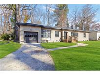 Charming ranch home featuring a garage, manicured lawn, and inviting front porch perfect for relaxing and enjoying the outdoors at 2191 Essex Sw Ave, Atlanta, GA 30311