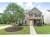 Charming two-story home with a well-manicured lawn, stone accents, and inviting front porch at 236 Creek View Ln, Acworth, GA 30102