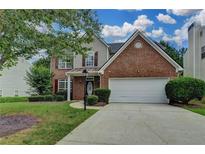 Charming two-story home featuring a brick facade, attached two-car garage, and well-manicured lawn at 2421 Fall Creek Lndg, Loganville, GA 30052