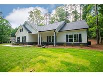 Beautiful one-story home with a white exterior, black shutters and large front yard at 5525 Belle Meade Dr, Villa Rica, GA 30180