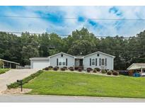 Charming single-story home with a well-manicured lawn and a driveway leading to an attached garage at 2711 Bluffton Rd, Buford, GA 30519