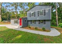Inviting two-story home featuring gray siding, black shutters, and a striking red front door at 4339 Rushmore Pl, Forest Park, GA 30297