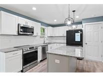 Modern kitchen featuring white cabinets, stainless steel appliances, and granite countertops at 4339 Rushmore Pl, Forest Park, GA 30297