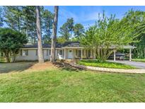 Charming single-story home with a welcoming front porch, lush lawn, and convenient carport in a tranquil setting at 1444 Arden Sw Dr, Marietta, GA 30008