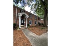 Exterior of a brick multi-Gathering home showcasing the columned entrance with a black front door at 6700 Roswell Rd # 11B, Atlanta, GA 30328