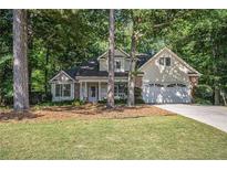 Charming home with a well-manicured lawn and lush greenery, featuring a two-car garage and inviting front porch at 2130 Hampton Se Trl, Conyers, GA 30013