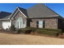Charming single story home with brick exterior, dark roof, manicured shrubbery and an attached two car garage at 3311 Lindenridge Dr, Buford, GA 30519