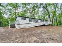 Charming home featuring a convenient ramp and deck, nestled among beautiful mature trees at 343 Compton Rd, Rockmart, GA 30153