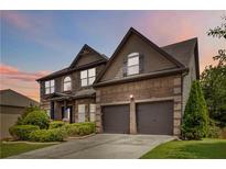Charming brick and siding home features a two-car garage and manicured landscaping at 4249 Caveat Ct, Fairburn, GA 30213