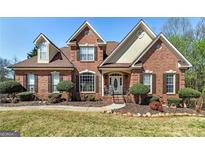 Charming two-story brick home with a manicured lawn and inviting front entrance with a portico at 149 Crown Glen Way, Stockbridge, GA 30281
