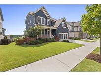 Charming two-story home featuring a well-manicured lawn and lush landscaping with blue siding and a welcoming porch at 326 Still Pine Bnd, Smyrna, GA 30082