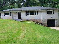 Charming one-story home featuring a stone foundation, freshly painted brick, and a well-manicured lawn at 2926 Monterey Dr, Decatur, GA 30032