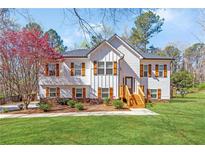 Charming two-story home with manicured lawn, wooden shutters, and a blossoming tree at 275 Cedars, Villa Rica, GA 30180