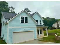 Charming two-story home featuring blue siding, a garage, and a well-manicured front lawn at 5341 Stewart Mill Rd, Douglasville, GA 30135