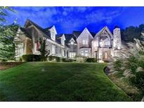 Stunning two-story home with stone and siding exterior, lush lawn, and manicured landscaping at 829 Big Horn Holw, Suwanee, GA 30024