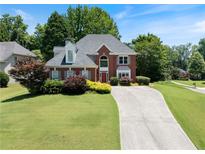 Charming two-story brick home featuring lush landscaping and a long driveway at 3820 Ridge Point Dr, Suwanee, GA 30024