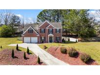Beautiful two-story brick home with a two car garage, a long driveway, and luscious landscaping at 949 Tumlin Trce, Lawrenceville, GA 30045