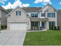 Charming two-story home with a well-manicured lawn and a classic white brick facade at 3222 Long Creek Dr, Buford, GA 30519