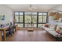 Bright living room features hardwood floors, large windows, and a cozy seating area with natural light at 1800 Clairmont Lk # 427, Decatur, GA 30033