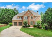 Charming two-story brick home with a well-manicured lawn, mature trees, and a spacious two-car garage at 4715 Mcintosh Drive Dr, Cumming, GA 30040