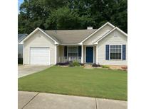 Charming single-story home with a well-manicured lawn, blue shutters, and an attached garage at 469 Village Cir, Stockbridge, GA 30281