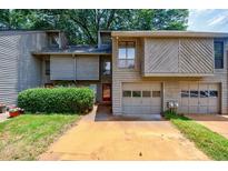 Charming townhouse with a two-car garage and lush green landscaping at 1002 Creatwood Se Cir, Smyrna, GA 30080