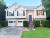 Charming home featuring a stone facade, two-car garage, and well-manicured front yard at 1047 Martin Heights Dr, Lawrenceville, GA 30044