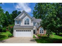 Charming two-story home with a two-car garage, manicured lawn, and beautiful landscaping at 348 Weatherstone Place Pl, Woodstock, GA 30188