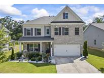 Charming two-story brick home with a well-manicured lawn and inviting front porch at 2260 Cedar Place Ct, Snellville, GA 30078