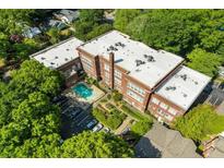 Aerial view showcases brick building with pool and verdant landscaping at 1041 State Nw St # 23, Atlanta, GA 30318