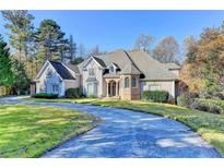 Charming home featuring a well-manicured lawn and a circular driveway, perfect for a Gathering at 3871 River Mansion Dr, Peachtree Corners, GA 30096