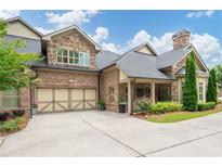 Charming brick home boasts a two-car garage, stone accents, manicured landscaping, and a welcoming covered entrance at 3178 Kenna Nw Dr, Acworth, GA 30101