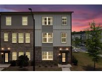 Charming townhome displaying a mix of brick and siding exterior at twilight at 1150 Buice Lake Pkwy, Acworth, GA 30102