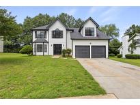 Charming two-story home with a well-maintained lawn and a two-car attached garage at 1069 Alford Rd, Lithonia, GA 30058