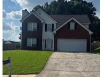Charming two-story home featuring a brick and siding facade, attached garage, and well-maintained front yard at 3065 Chandon Ln, Lawrenceville, GA 30044