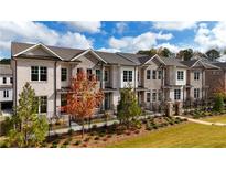 Charming three-story townhomes boast brick exteriors, black iron fences, and manicured landscaping at 606 Goldsmith Ct # 114, Johns Creek, GA 30022