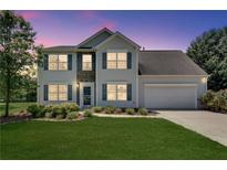 Charming two-story home with a well-manicured lawn, attached garage, and stone facade at 7550 Springmill Ct, Cumming, GA 30028