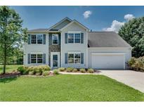 Charming two-story home featuring stone accents, a well-manicured lawn, and an attached two-car garage at 7550 Springmill Ct, Cumming, GA 30028