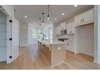 Bright kitchen features a large island, modern appliances, and hardwood floors at 1931 Deco Dr, Kennesaw, GA 30144
