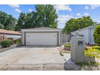 Detached two-car garage with a white door and gray brick exterior, complemented by a spacious driveway at 935 Bobcat Se Ct, Marietta, GA 30067