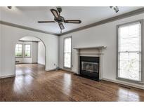 Spacious living room with hardwood floors, fireplace, ceiling fan, and arched doorway at 105 Bruton St, Decatur, GA 30030