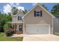 Charming two-story home featuring a covered porch, two-car garage, and tasteful neutral siding at 108 Spring View Br, Dallas, GA 30157