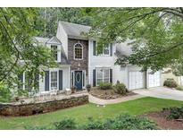 Charming two-story home with stone accents, manicured landscaping, and a welcoming front patio with seating at 2429 Brookgreen Nw Commons, Kennesaw, GA 30144