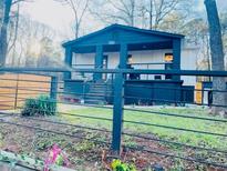 Charming home with a covered porch, black fencing and lush landscaping at 3236 Jonesboro Rd, Atlanta, GA 30354