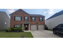 Charming two-story brick home featuring a well-manicured lawn and an attached two-car garage at 3484 Enterkin Ln, Atlanta, GA 30349