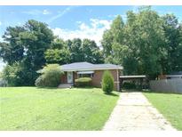 Cozy single-story home with a carport, mature trees, and a well-manicured lawn at 1024 Magnolia Dr, Smyrna, GA 30082