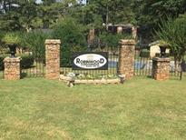 Welcoming community entrance featuring stone pillars, black iron fencing, and the Robinwood Condominiums signage at 2340 Beaver Ruin Rd # 89, Norcross, GA 30071