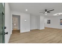 Bright living room featuring hardwood floors, ceiling fan, and freshly painted white walls at 2358 Tilson Rd, Decatur, GA 30032